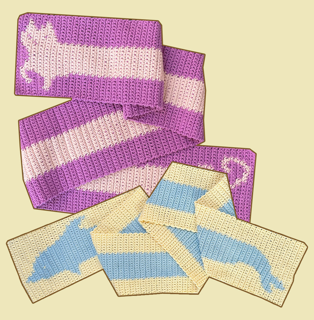 A stylish pink and white scarf from the "Crochet pattern combo pack ✧ Pet scarves" by devout hand, featuring a charming reindeer pattern on both ends, is displayed on a checkered green and white rug.